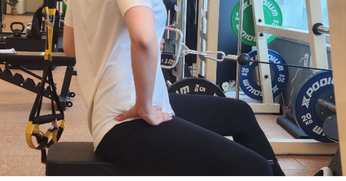 앉은 자세에서 손으로 허리·골반 위치를 짚어 확인하는 모습 — 동탄 내몸에미소